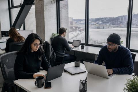 A diverse software team works together in a modern Pittsburgh office.